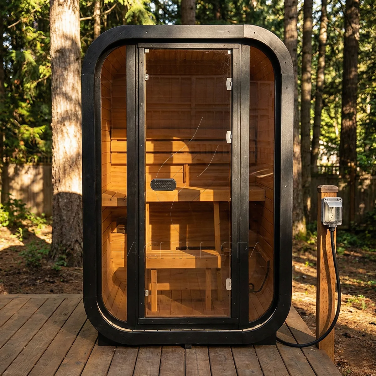 Installed CS04 outdoor cube sauna showing the front entry, interior benches and outdoor electrical connection context.