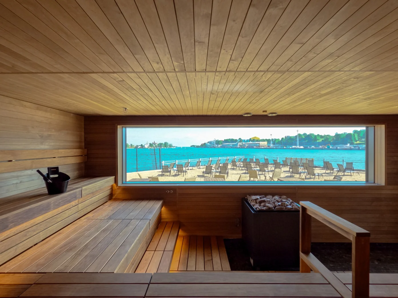 Indoor sauna with timber benches and a panoramic window