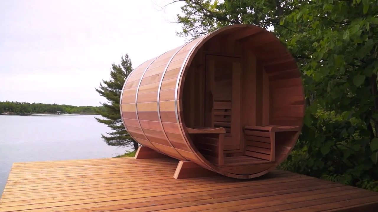 Outdoor barrel sauna beside a lake