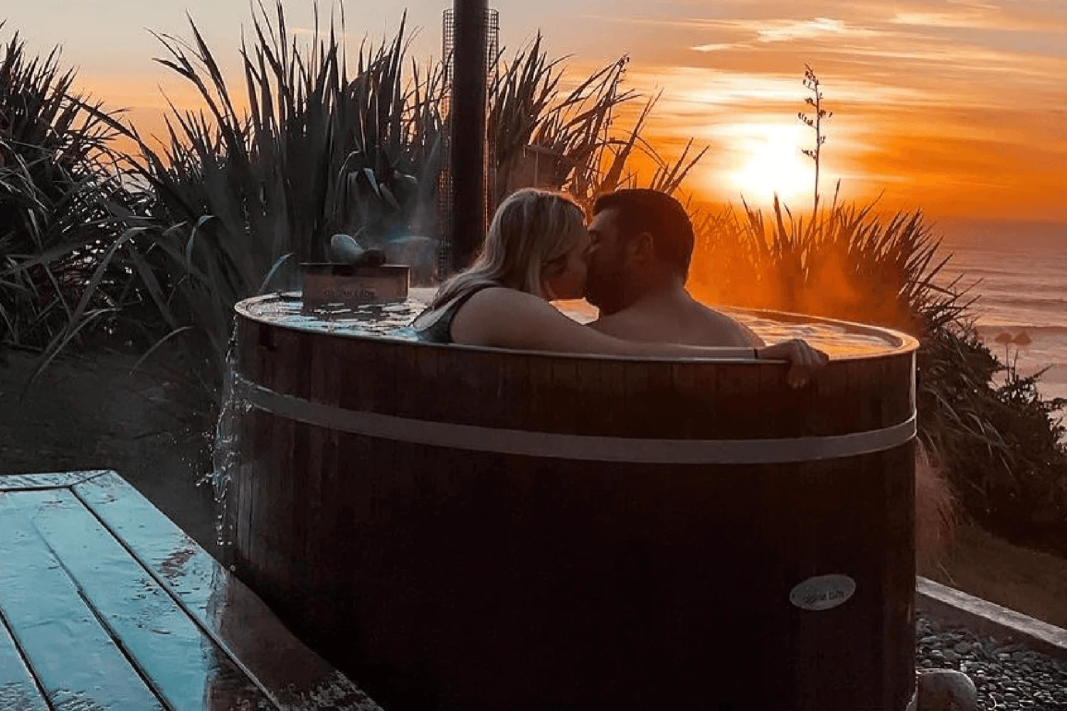Pareja usando una bañera nórdica calentada con leña