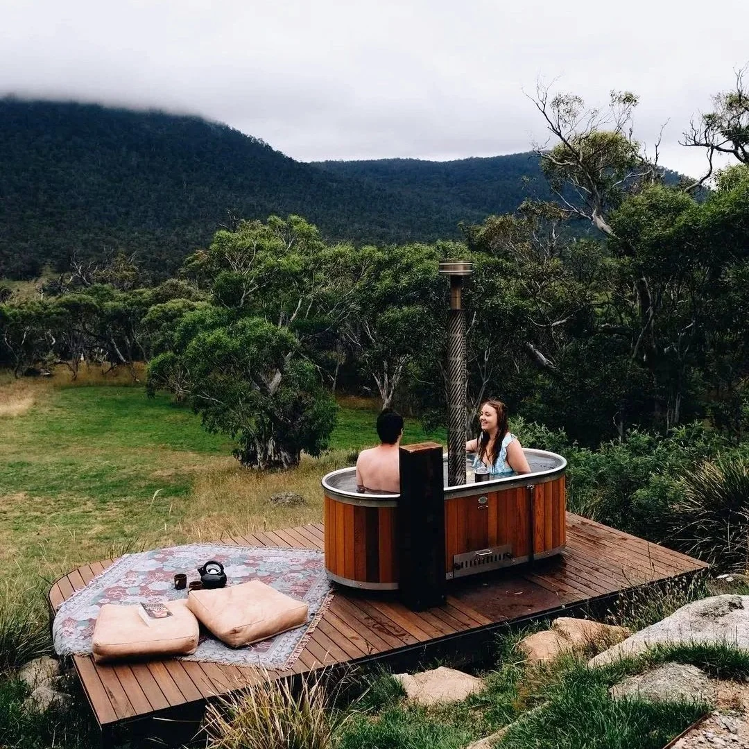 Wood-fired hot tub in a mountain landscape