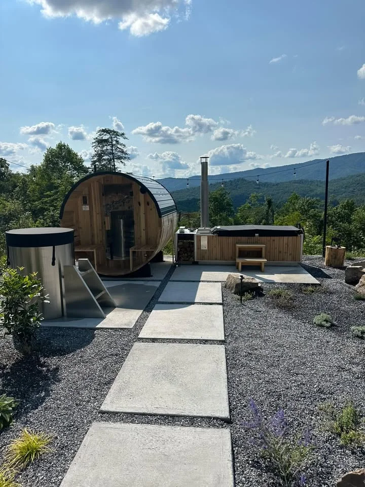 Completed outdoor wellness project with barrel sauna, stainless steel cold plunge and wood-fired hot tub